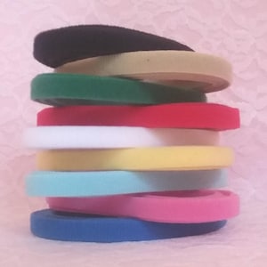 May include: A stack of ten different colored hook and loop fasteners. The colors are black, green, red, white, yellow, light blue, pink, and blue.