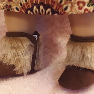 May include: A pair of brown suede boots with faux fur trim. The boots have a pointed toe and a low heel.