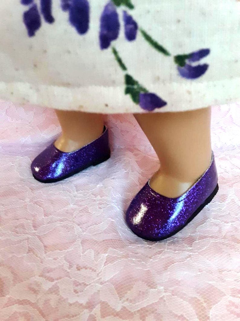 May include: A pair of purple glitter shoes with a rounded toe and a low heel.