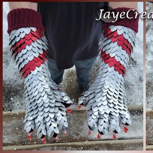May include: A pair of burgundy knitted gloves with silver and red scale-like accents. The gloves have long sleeves and extend up the forearm. The fingertips are white with red stripes. The text "JayeCreations" is in the upper right corner.