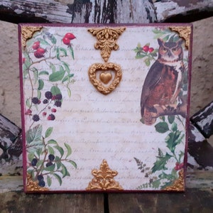 Peut inclure: Une plaque en bois décorative avec un motif floral vintage, comprenant un cœur en or, un hibou et un texte manuscrit. La plaque a une bordure rouge et est ornée d'accents dorés.
