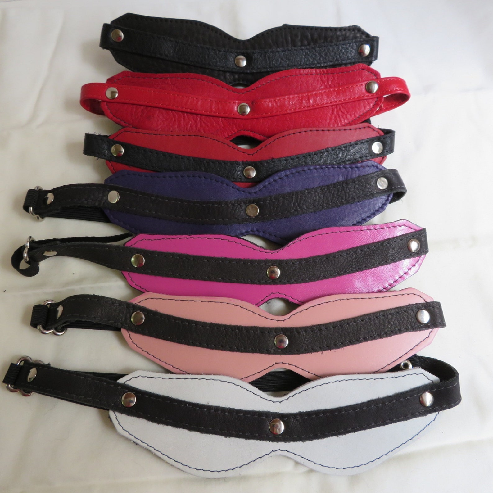 Assorted leather BDSM blindfolds in multiple colors with plush fur lining for bondage restraints