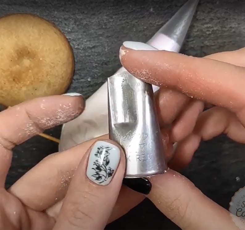 May include: A silver metal piping tip with a star-shaped opening. The tip is labeled "17" and "K REAL".