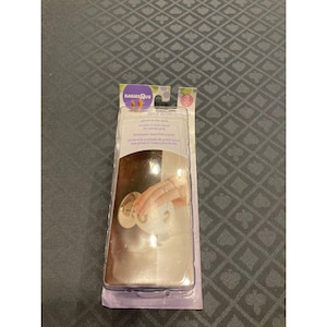 May include: A packet of Babies R Us door knob covers. The clear plastic packaging shows a hand using the cover on a door knob. The text on the package says "glows in the dark" and "access to door knob for easier grip".