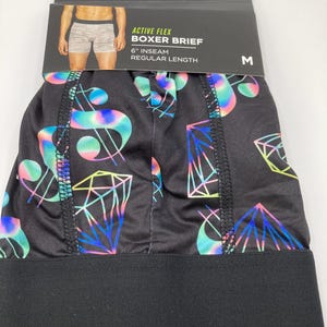 May include: Black boxer briefs with a colorful dollar sign and diamond pattern. The waistband is black and the tag says "Active Flex Boxer Brief 6" inseam Regular Length" and "rue21." The size is M.