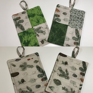 Puede incluir: Conjunto de cuatro agarraderas de olla de tela verde y marrón con un diseño de pino y piña. Las agarraderas de olla están hechas de tela de patchwork con diferentes patrones.