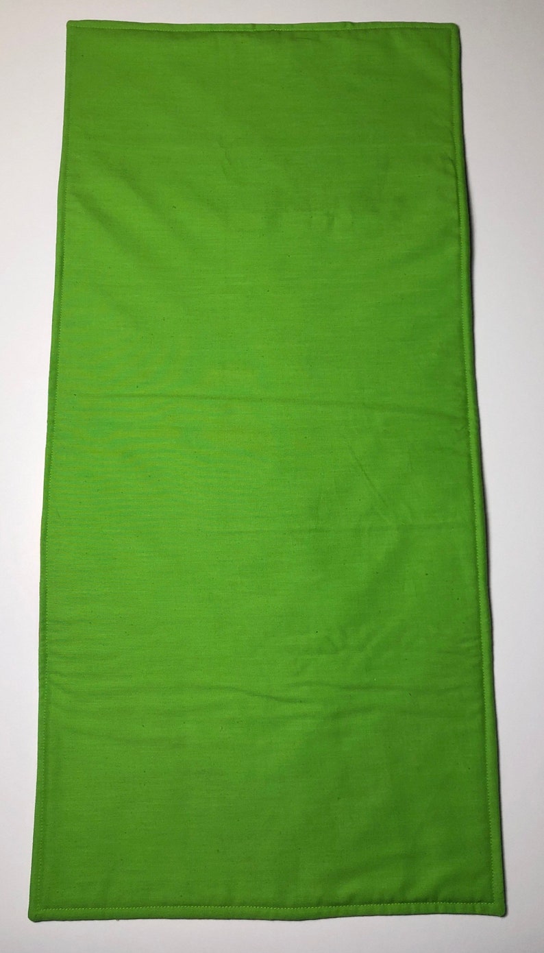 May include: A solid green rectangular fabric placemat with a stitched border.
