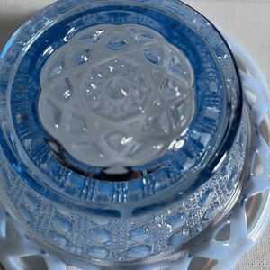 K&ouml;nnte beinhalten: Eine blaue Glassch&uuml;ssel mit einer wei&szlig;en Spitzenborte. Die Sch&uuml;ssel hat ein strukturiertes Design und ist aus undurchsichtigem Glas.
