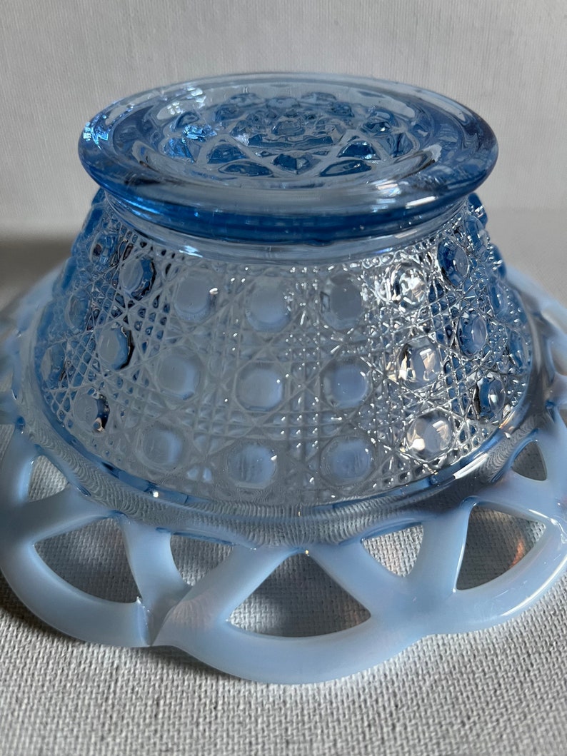K&ouml;nnte beinhalten: Eine hellblaue Glassch&uuml;ssel mit einem gewellten Rand und einem strukturierten Boden. Die Sch&uuml;ssel ist aus Milchglas und hat einen Vintage-Look.