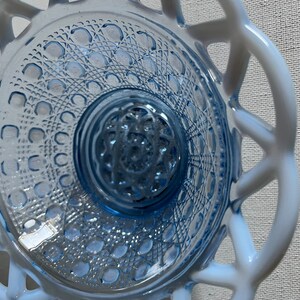 K&ouml;nnte beinhalten: Eine blaue Glassch&uuml;ssel mit einem wei&szlig;en Spitzenmuster am Rand. Die Sch&uuml;ssel hat ein strukturiertes Muster auf dem Boden.