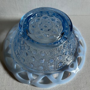 K&ouml;nnte beinhalten: Eine blaue Glassch&uuml;ssel mit einem erhabenen Muster auf dem Boden und einem wei&szlig;en Milchglasfu&szlig; mit einem spitzem Design.
