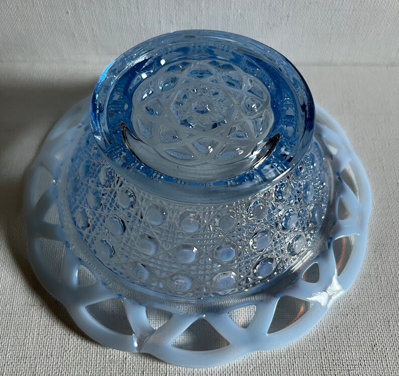 K&ouml;nnte beinhalten: Eine blaue Glassch&uuml;ssel mit einem erhabenen Muster auf dem Boden und einem wei&szlig;en Milchglasfu&szlig; mit einem spitzem Design.