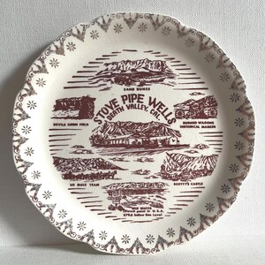 Puede incluir: Un plato de cerámica blanca vintage con borde festoneado y borde marrón. El plato presenta ilustraciones de lugares emblemáticos de Death Valley, como Sand Dunes, Scotty's Castle y 20 Mule Team. El texto incluye "Stove Pipe Wells, Death Valley, Cal."