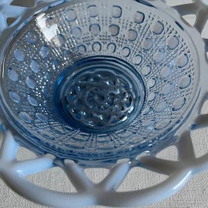 K&ouml;nnte beinhalten: Eine blaue Glassch&uuml;ssel mit einem wei&szlig;en Spitzenmuster am Rand. Die Sch&uuml;ssel hat eine strukturierte, gemusterte Oberfl&auml;che.