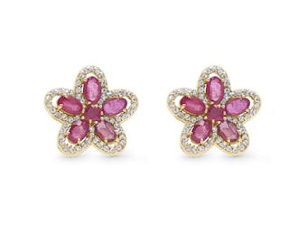 May include: A pair of gold earrings with a flower design. The earrings are set with red rubies and white diamonds.