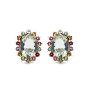 May include: A pair of gold earrings with a large oval green gemstone surrounded by a halo of smaller multi-colored gemstones.