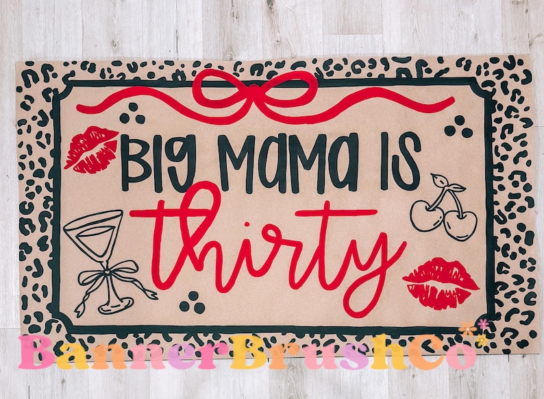 May include: Tan doormat with a black border and leopard print trim. The mat features the text "BIG MAMA IS thirty" in black and red, along with illustrations of lips, cherries, and a cocktail glass.