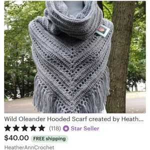 May include: Gray crocheted hooded scarf with fringe. The scarf is made with a lacy stitch pattern and has a cowl neck.