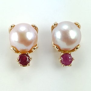 May include: A pair of gold earrings with a pearl and a ruby gemstone. The pearls are white and the rubies are red.
