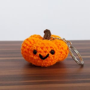 Könnte beinhalten: Eine weiße Keramik-Tasse mit schwarzem Henkel und dem Text "But First, Coffee" in fetter, schwarzer Schrift. Die Tasse steht vor einem verschwommenen Hintergrund, der eine gemütliche Umgebung suggeriert.