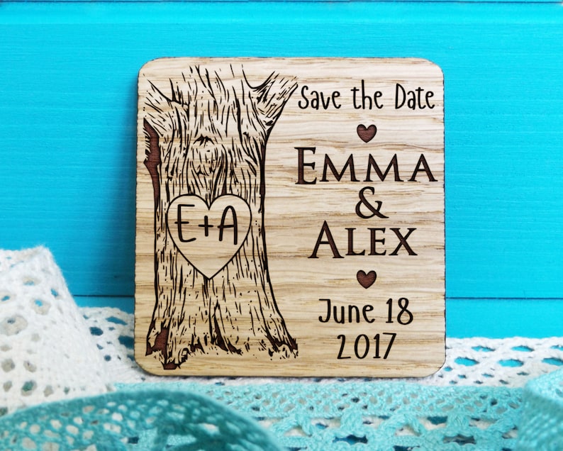 May include: A wooden save the date magnet with a tree design. The text reads "Save the Date", "Emma & Alex", "June 18, 2017" and "E+A" inside a heart.
