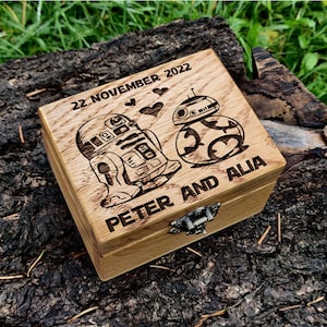 May include: A wooden box with a hinged lid, engraved with the date "22 November 2022", the names "Peter and Alia", and images of the Star Wars characters R2-D2 and BB-8.