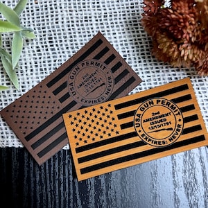 May include: Two wooden plaques with an American flag design and the text "USA GUN PERMIT 2nd AMENDMENT ISSUED 12/15/1791 EXPIRES: NEVER" in a circle.
