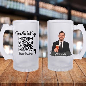 May include: Two frosted glass beer mugs with white handles. One mug has the text "Time To Suit Up" above a QR code and the text "Check This Out". The other mug has a graphic of a man in a suit holding a beer, with the name "Jeremy" on a banner.