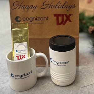 May include: A gift set featuring a white coffee mug and a white tumbler, both branded with the "cognizant" logo. A gold coffee bag is inside the mug. A brown paper bag with "Happy Holidays" and "TJX" printed on it is in the background.