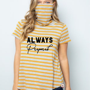 May include: A yellow and gray striped shirt with a black graphic that says "ALWAYS Prepared". The shirt has a turtleneck and a face mask attached to the neck.