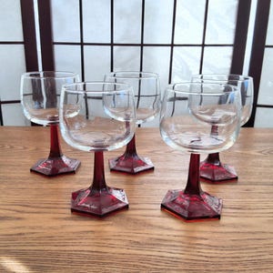 Peut inclure: Ensemble de cinq verres à vin en verre transparent avec des bases hexagonales rouges.