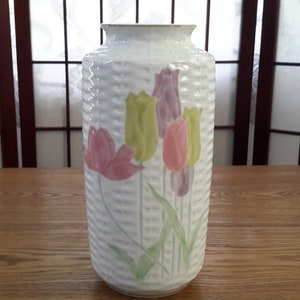 Peut inclure: Vase en céramique blanche avec un motif tissé et un motif floral de tulipes roses, violettes et jaunes.