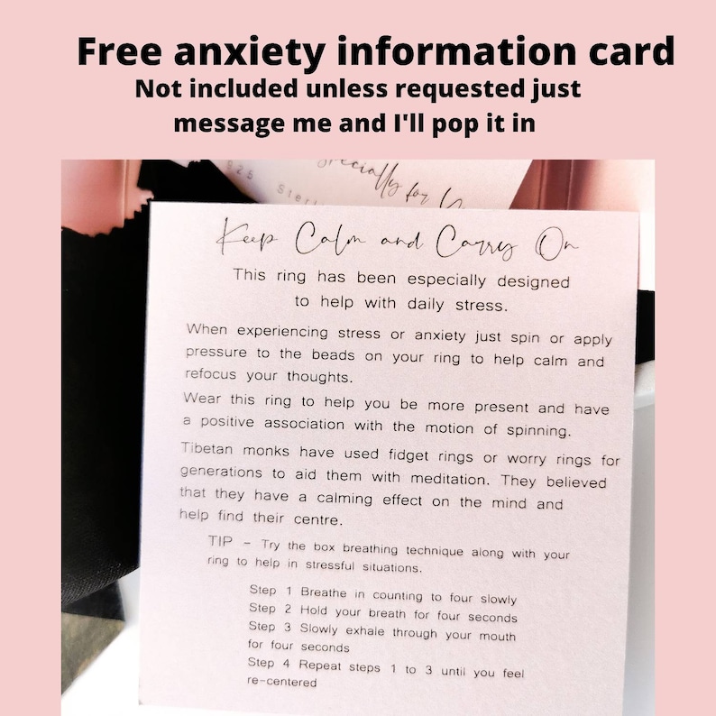 May include: A white card with pink text that reads "Free anxiety information card" and "Keep Calm and Carry On". The card explains how to use a fidget ring to help with stress and anxiety. It includes a tip on box breathing.