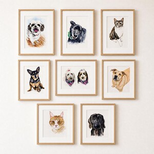 May include: A collection of eight framed watercolor portraits of various dogs and cats. The artwork features individual and paired pet illustrations in light wood frames, showcasing diverse breeds, colors, and expressions against white backgrounds.