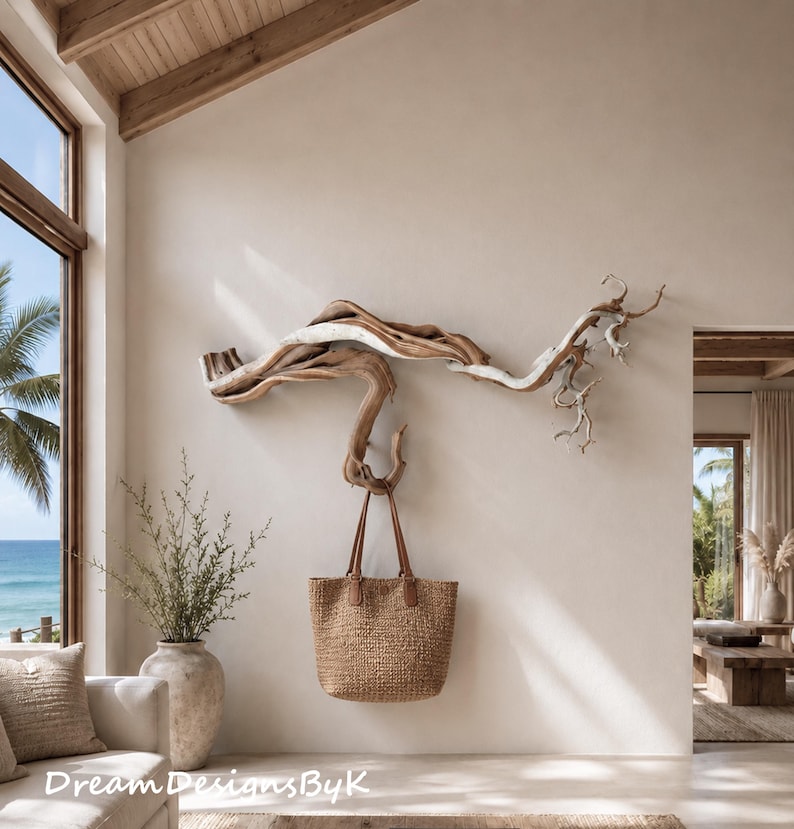 May include: A large, horizontal piece of natural driftwood mounted on a wall, functioning as a wall hook. A brown woven tote bag with leather handles hangs from the driftwood. The text DreamDesignsByK is visible in the bottom left corner.