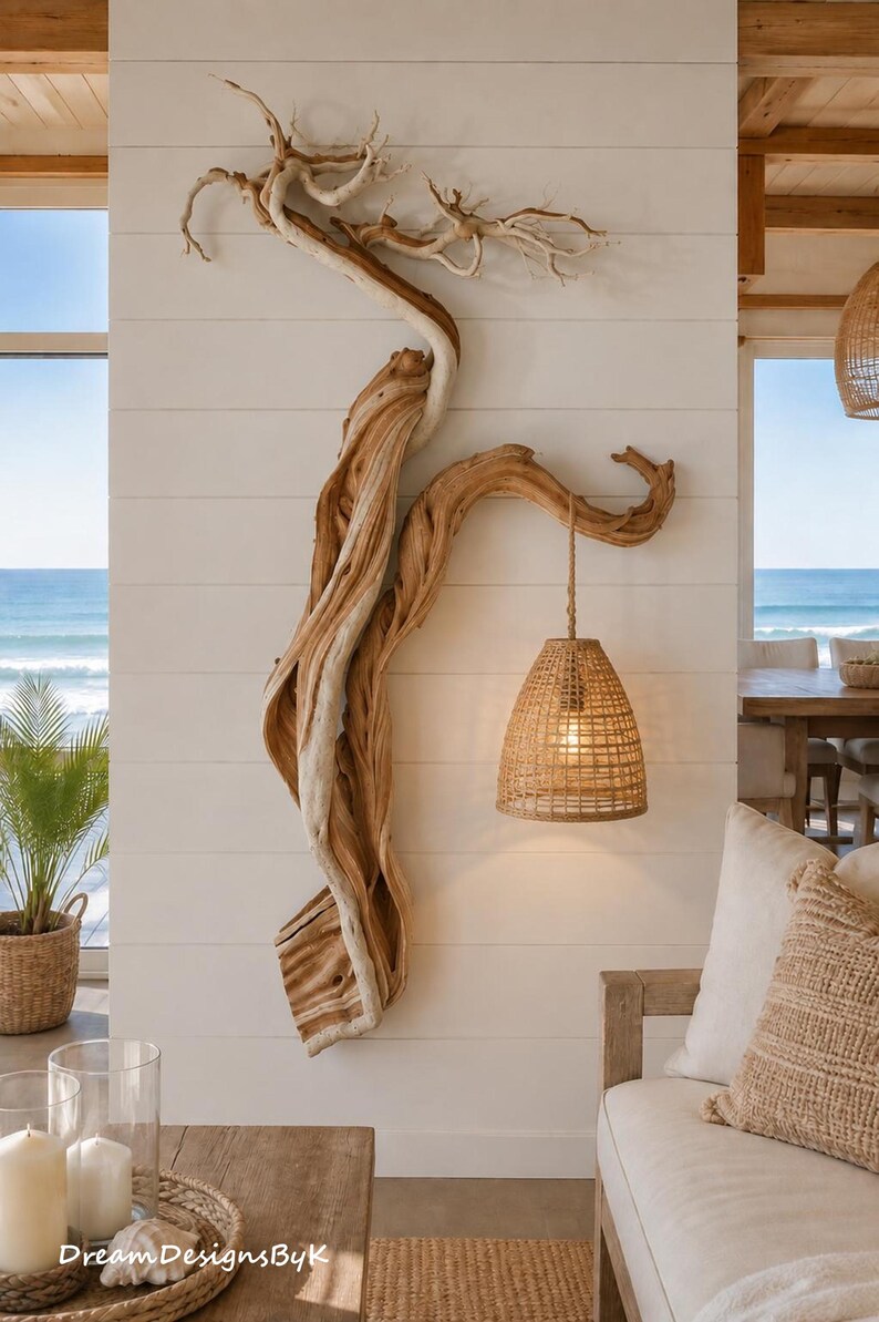 May include: A wall-mounted light fixture featuring a large, natural, twisted piece of driftwood that extends vertically. A woven, bell-shaped rattan lampshade hangs from a sturdy rope attached to a branch of the wood, emitting a warm, soft glow.