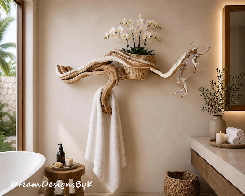 May include: A wall-mounted driftwood towel rack featuring a natural light brown wood grain, a woven basket holding a white orchid plant, and a white towel hanging from a curved branch section. The piece is mounted on a smooth beige wall.