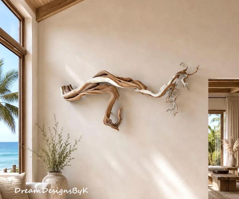 May include: A large, horizontal wall sculpture crafted from natural, weathered driftwood. The piece features organic, twisting branches with a smooth, light-to-medium brown wood grain texture, extending across the wall in a fluid, asymmetrical shape.