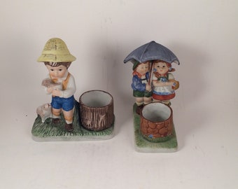 Vintage candle holder pair: Vergasi Boy with puppies and CMA boy and girl under umbrella at wishing well 1980's