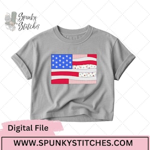 Puede incluir: Una camiseta gris con un diseño bordado de la bandera estadounidense. La bandera incorpora rayas rojas y blancas, un campo azul con estrellas blancas y secciones con estampado floral. También se ve el texto "Digital File" y "WWW.SPUNKYSTITCHES.COM".