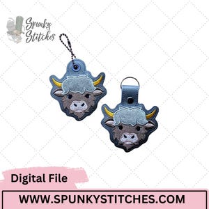 May include: Two embroidered keychains shaped like a yak's head. The yak has a gray face, light blue fur, and yellow horns. One keychain has a chain, the other has a leather loop. The text "Digital File" and "WWW.SPUNKYSTITCHES.COM" are also visible.