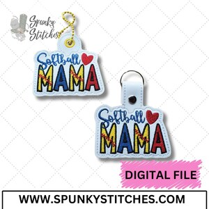 May include: Softball Mama keychains with a red heart and a baseball design. The keychains are white with blue, yellow, and red embroidery. The text "Softball Mama" is embroidered on the keychains.