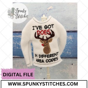 May include: White long-sleeved sweater with the text "I'VE GOT DOES" above a brown deer head with red accents. The text "IN DIFFERENT AREA CODES" is below the deer. The image also includes the text "DIGITAL FILE" and "WWW.SPUNKYSTITCHES.COM".