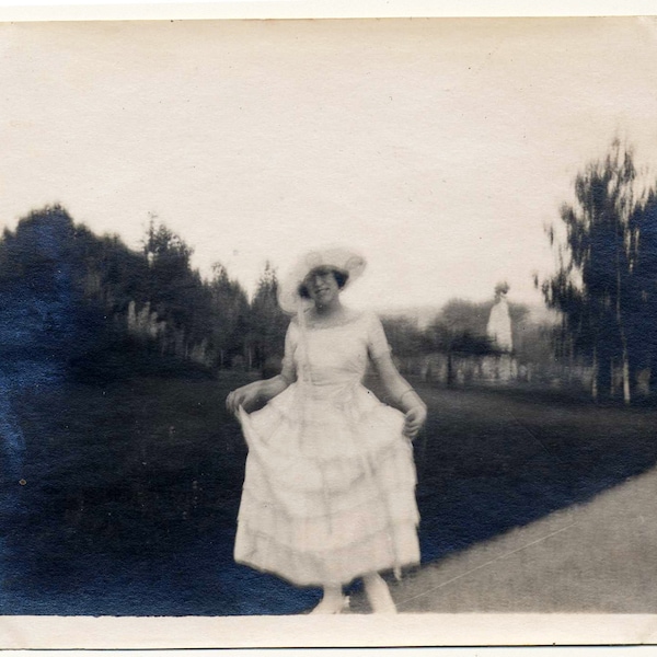 vintage photo ancienne jeune femme qui montre sa belle robe blanche