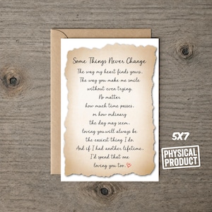 May include: A 5x7 greeting card with a deckled-edge parchment-style overlay featuring the black printed text: Some Things Never Change, The way my heart finds yours, The way you make me smile without even trying, No matter how much time passes.