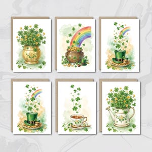 May include: Set of six St. Patrick's Day greeting cards. Each card features watercolor illustrations of shamrocks, pots of gold, rainbows, and leprechaun hats. The cards have a watercolor background with a brown border.