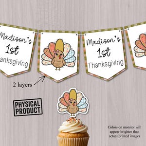 May include: A banner with the text "Madison's 1st Thanksgiving" and a turkey illustration. The turkey has a pink bow and colorful tail feathers. A cupcake with a turkey topper is in front of the banner. The image also includes a "Physical Product" stamp.