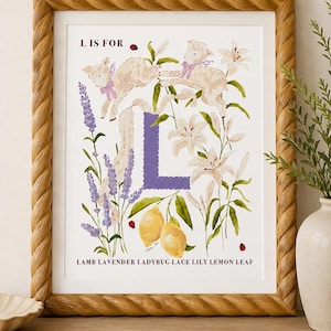 May include: A framed art print featuring the letter L in purple with a scalloped edge, surrounded by watercolor illustrations of lambs, lavender, lilies, lemons, and ladybugs. The text L IS FOR and LAMB LAVENDER LADYBUG LACE LILY LEMON LEAF is printed.