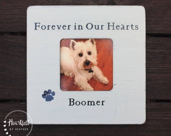 May include: White wooden picture frame with a blue paw print and the text "Forever in Our Hearts" and "Boomer". A photo of a white dog is in the frame.