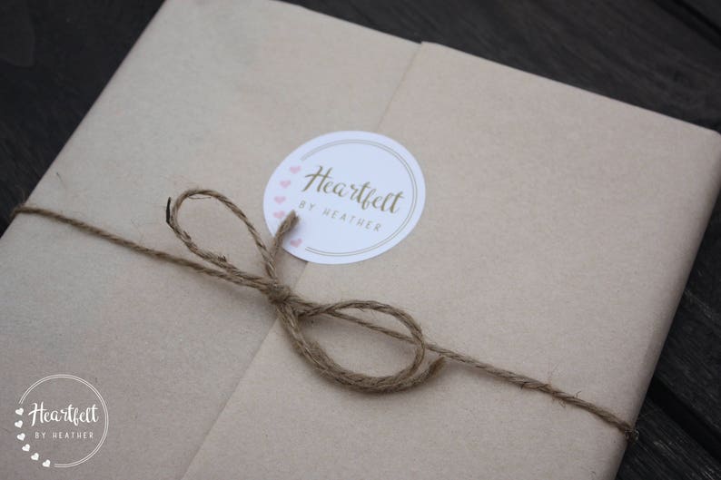 May include: A brown paper package tied with twine and a white circle sticker that says "Heartfelt by Heather" with pink hearts around the edge.